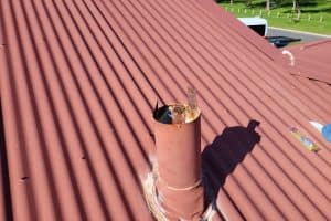 A rusted metal roof vent